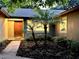 Inviting front entrance with a warm-toned door framed by lush landscaping and accent lighting at 8825 Larwin Ln, Orlando, FL 32817