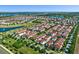 Aerial view of a community showcasing red-tiled roofs, lush landscaping, and shimmering lakes at 8848 Bismarck Palm Dr, Winter Garden, FL 34787