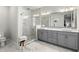 Bright bathroom features a glass shower, marble floors and walls, and a dual sink vanity at 8848 Bismarck Palm Dr, Winter Garden, FL 34787