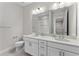 Bright bathroom with a dual sink vanity, modern fixtures, and a toilet with towel bar at 8848 Bismarck Palm Dr, Winter Garden, FL 34787