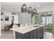 Elegant kitchen with island, white counter tops and sleek pendant lights, adjoining dining area with modern dining table at 8848 Bismarck Palm Dr, Winter Garden, FL 34787