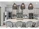 Stylish kitchen with stainless steel appliances, gray cabinetry, mosaic tile backsplash, and island with barstool seating at 8848 Bismarck Palm Dr, Winter Garden, FL 34787
