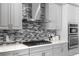 Close up of gourmet kitchen with sleek stainless steel appliances, modern cabinetry, and stylish tile backsplash at 8848 Bismarck Palm Dr, Winter Garden, FL 34787