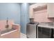 Laundry room featuring tile, stainless steel washer and dryer units, and light blue walls at 8848 Bismarck Palm Dr, Winter Garden, FL 34787