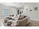 Inviting living room with large sectional sofa, decorative poufs, modern decor and bright natural light at 8848 Bismarck Palm Dr, Winter Garden, FL 34787