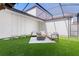 Outdoor patio featuring artificial grass, a fire pit, and modern furniture under a transparent roof at 8848 Bismarck Palm Dr, Winter Garden, FL 34787