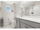 Bright bathroom with gray vanity, and a shower with white curtain at 889 Boxelder Ave, Minneola, FL 34715
