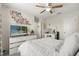 Bright bedroom with a white bedspread, vanity, and decorations on the wall at 889 Boxelder Ave, Minneola, FL 34715