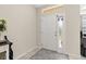 Bright entryway with a neutral color palette and decorative rug featuring a white front door at 889 Boxelder Ave, Minneola, FL 34715