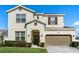 Charming two-story home featuring a well-manicured lawn, complemented by a two-car garage and neutral color palette at 889 Boxelder Ave, Minneola, FL 34715
