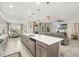 Open-concept kitchen and living area with a large island, dining table, and modern furnishings at 889 Boxelder Ave, Minneola, FL 34715