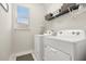 Bright laundry room featuring a washer and dryer with storage shelf above window providing natural light at 889 Boxelder Ave, Minneola, FL 34715