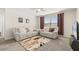 Well lit living room with plush reclining furniture, ceiling fan, carpet, and decorative window treatments at 889 Boxelder Ave, Minneola, FL 34715