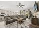 Open-concept living room featuring a large sectional sofa, ceiling fan, and modern decor at 889 Boxelder Ave, Minneola, FL 34715