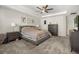 Comfortable main bedroom with king bed, carpet, ceiling fan and furniture, artwork on the walls at 889 Boxelder Ave, Minneola, FL 34715