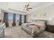 Spacious main bedroom boasts a king bed, plush carpeting, ceiling fan and natural light from the windows at 889 Boxelder Ave, Minneola, FL 34715