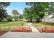 Large backyard featuring a stone pathway, mulch beds, mature trees, and a white fence at 905 Cascade Falls Ln, Deland, FL 32720