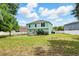 Green, grassy backyard with a two-story home, landscaping, and a privacy fence at 905 Cascade Falls Ln, Deland, FL 32720