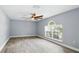 Bedroom with wood floors, a ceiling fan, and a large window at 905 Cascade Falls Ln, Deland, FL 32720