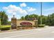 Cascades Park community entrance sign with stone accents, colorful flowers, and lush landscaping at 905 Cascade Falls Ln, Deland, FL 32720