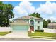 Inviting two-story home with a two-car garage, well-manicured lawn, and beautiful landscaping at 905 Cascade Falls Ln, Deland, FL 32720