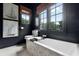 Bathroom featuring a large soaking tub, tiled walls, and black trim at 906 Alhambra Ct, Orlando, FL 32804