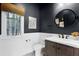 Stylish bathroom with dark blue walls, vanity with a white sink, and a window view at 906 Alhambra Ct, Orlando, FL 32804
