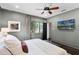 This primary bedroom offers a ceiling fan, natural light, neutral walls and a mounted TV at 906 Alhambra Ct, Orlando, FL 32804