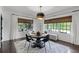 Open dining area with modern light fixture, a round dining table and neutral-toned windows at 906 Alhambra Ct, Orlando, FL 32804