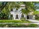 Stunning two-story home featuring a red tile roof, lush landscaping, and a porte-cochère at 906 Alhambra Ct, Orlando, FL 32804