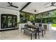 Outdoor kitchen and dining area with a built in grill, ceiling fans and an outdoor dining set at 906 Alhambra Ct, Orlando, FL 32804