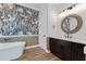 Modern bathroom with a standalone tub, vanity, and designer wallpaper at 907 Celadon St, Winter Garden, FL 34787