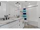 Bright bathroom featuring double vanity with stone countertop, white cabinets, and tiled shower with modern fixtures at 907 Celadon St, Winter Garden, FL 34787