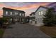 A well-lit home at dusk with a stone driveway, garage, and manicured landscaping at 907 Celadon St, Winter Garden, FL 34787