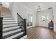 Elegant foyer with a black-and-white staircase, wood flooring, and a view of the front entrance at 907 Celadon St, Winter Garden, FL 34787