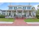 An impressive two-story home with a covered porch, elegant columns, and a brick walkway at 907 Celadon St, Winter Garden, FL 34787