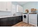 Functional laundry room with modern washer and dryer and extra counter space and cabinets at 907 Celadon St, Winter Garden, FL 34787