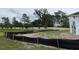A spacious backyard under construction with a fence and view of many tall green trees at 960 Hawksnest Pt, Oviedo, FL 32765