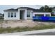 Under construction exterior of a white home with a three-car garage and large windows on a cloudy day at 960 Hawksnest Pt, Oviedo, FL 32765