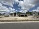 New home construction featuring a three car garage and modern architectural details under a cloudy sky at 960 Hawksnest Pt, Oviedo, FL 32765