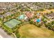 A captivating aerial view of a community pool, tennis courts, and lush landscaping, inviting relaxation and recreation at 9574 Meadow Hunt Way, Winter Garden, FL 34787
