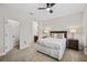 Bright bedroom featuring ceiling fan, view of the bathroom, and a comfortable bed at 9574 Meadow Hunt Way, Winter Garden, FL 34787