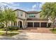 Stunning two-story home featuring a three-car garage and a brick paved driveway at 9574 Meadow Hunt Way, Winter Garden, FL 34787