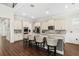 Spacious kitchen with white cabinetry, granite countertops, stainless steel appliances, and bar seating at 9574 Meadow Hunt Way, Winter Garden, FL 34787