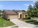 Beautiful home with a well-maintained lawn, mature landscaping, and attached two-car garage at 1023 Hermosa Way, Kissimmee, FL 34744