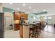 Open kitchen with granite countertops, stainless steel appliances, dark wood cabinets, and barstool seating at 1023 Hermosa Way, Kissimmee, FL 34744