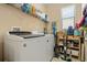 A laundry room with appliances, shelves, and natural light from the window at 1023 Hermosa Way, Kissimmee, FL 34744