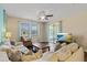Comfortable living room with a large sofa, ceiling fan, and sliding glass doors to the screened-in lanai at 1023 Hermosa Way, Kissimmee, FL 34744