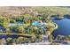 Panoramic aerial view showcases a pool, tennis courts, and lake amidst lush greenery in a peaceful neighborhood at 1131 Indigo Dr, Celebration, FL 34747