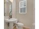 Powder room with a pedestal sink, decorative mirror, and a window at 1131 Indigo Dr, Kissimmee, FL 34747